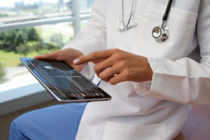 Une doctoresse qui consulte une tablette.