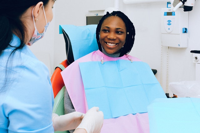 Femme souriante pendant une séance de soins dentaires.